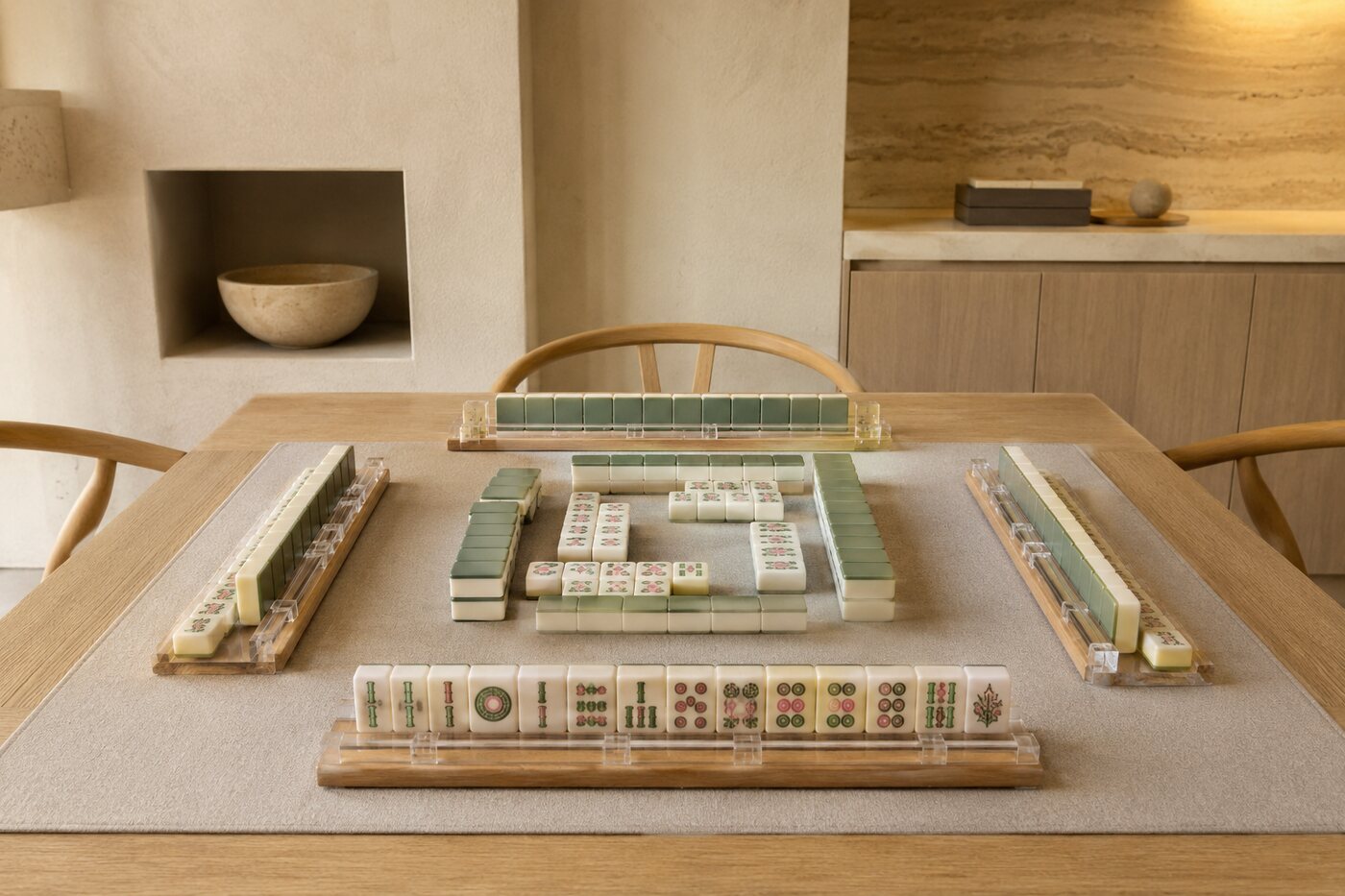Modern mahjong game arranged on a pale oak table in a warm organic-modern room